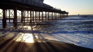 A pier extending into the ocean with a building on one end. - The Cliffden Hotel (Teignmouth)