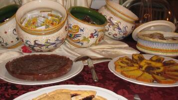 A table with various dishes and bowls, including a pie and a fruit tart.