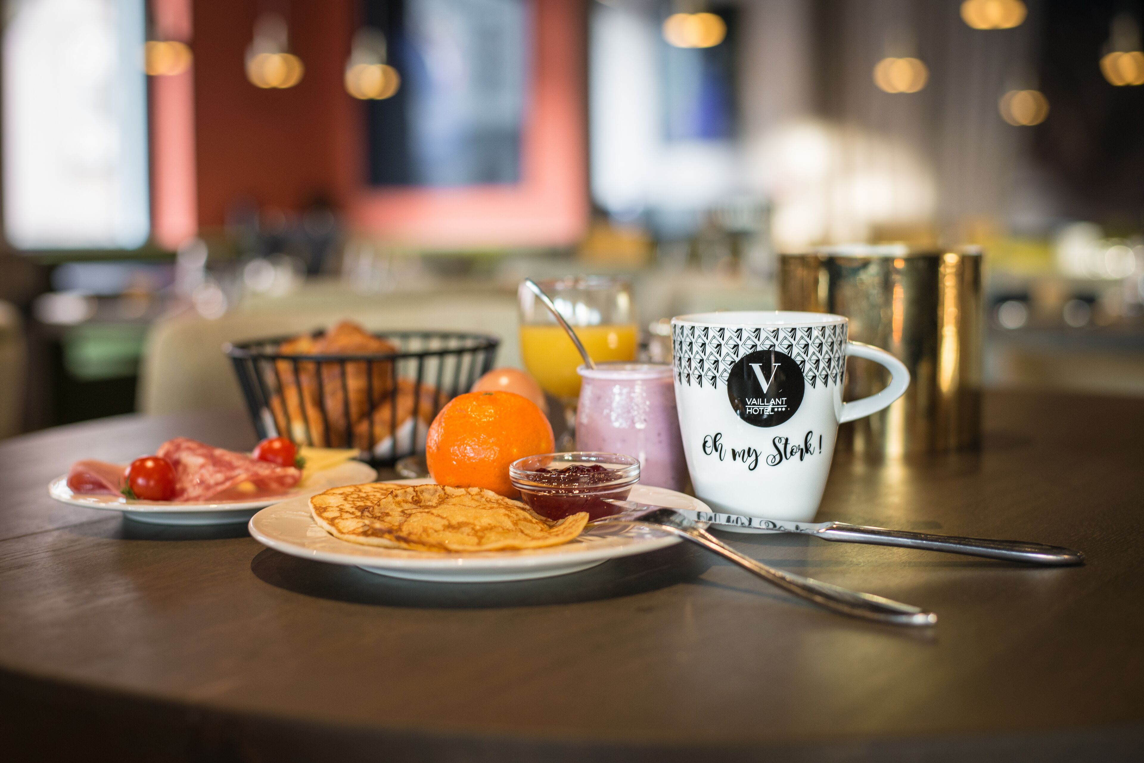 Et morgenbord med mad, en kop og en skål med frugt.