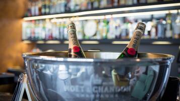 Un'area bar con un grande secchio di metallo contenente due bottiglie di champagne Moët & Chandon.