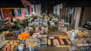 A buffet with various food items and a seating area with tables and chairs. - Hotel Restaurant Vaillant proche Europapark-Rulantica (Sélestat)