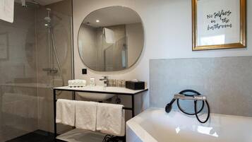 Une salle de bain moderne avec un grand miroir, une baignoire et une douche.