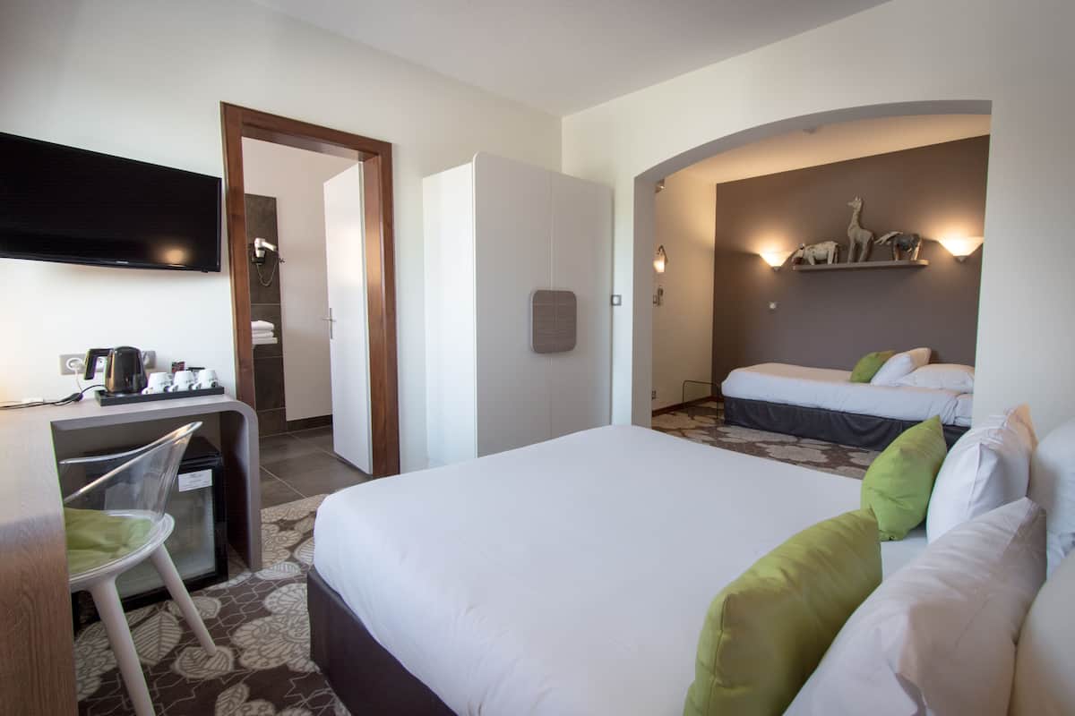 Deluxe driepersoonskamer | Luxe beddengoed, een kluis op de kamer, een bureau, geluiddichte muren