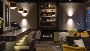 Un interior moderno con una zona de bar, asientos y una chimenea.