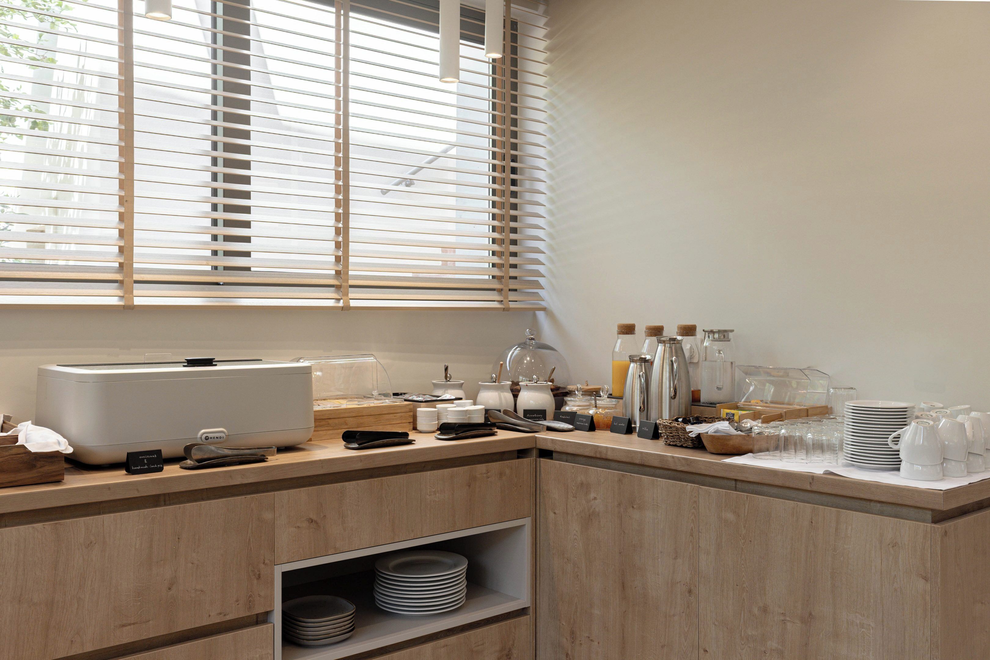 A breakfast bar with a coffee machine, tea kettle, and various breakfast items.