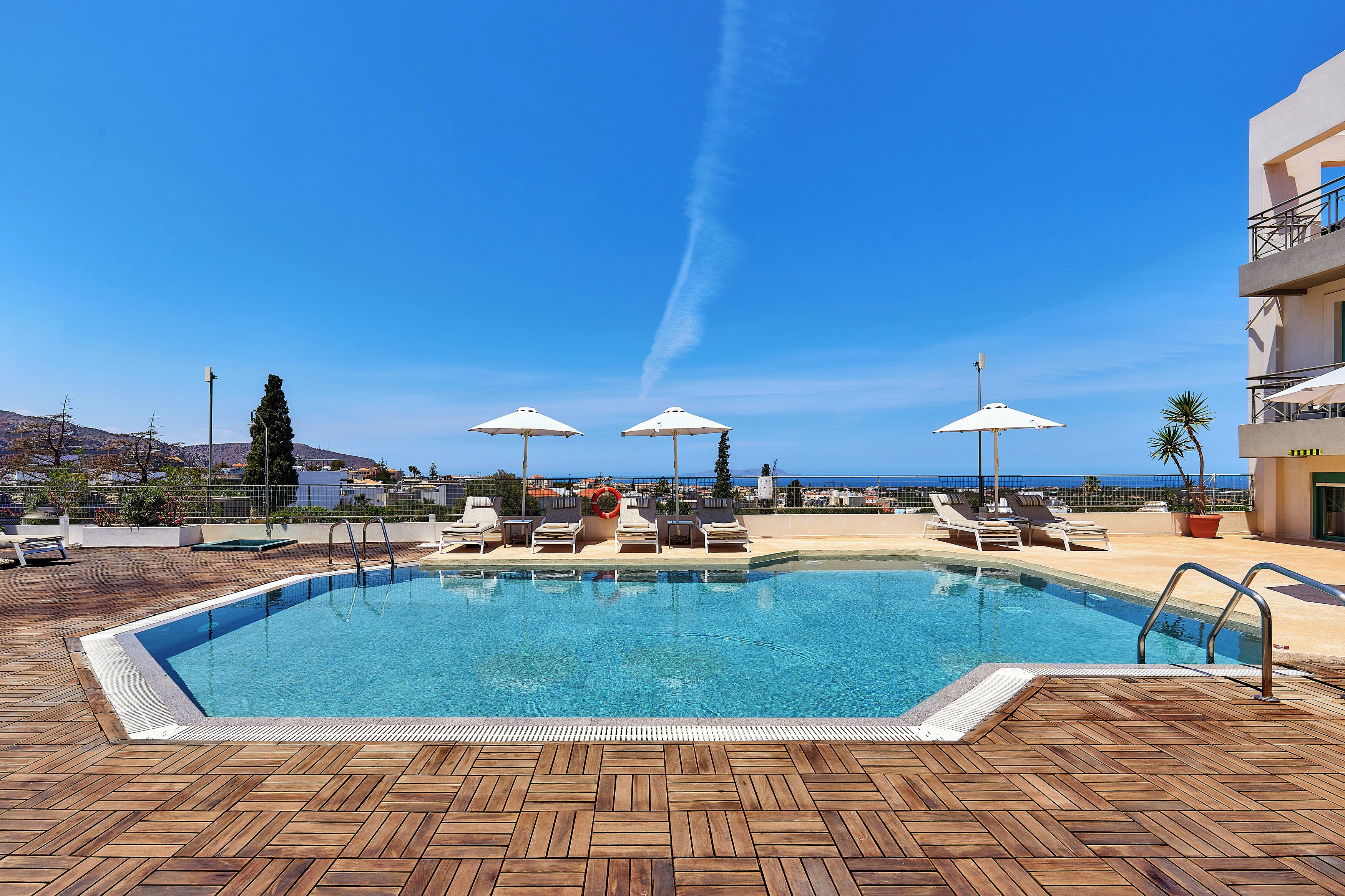 Una piscina al aire libre de temporada, sombrillas