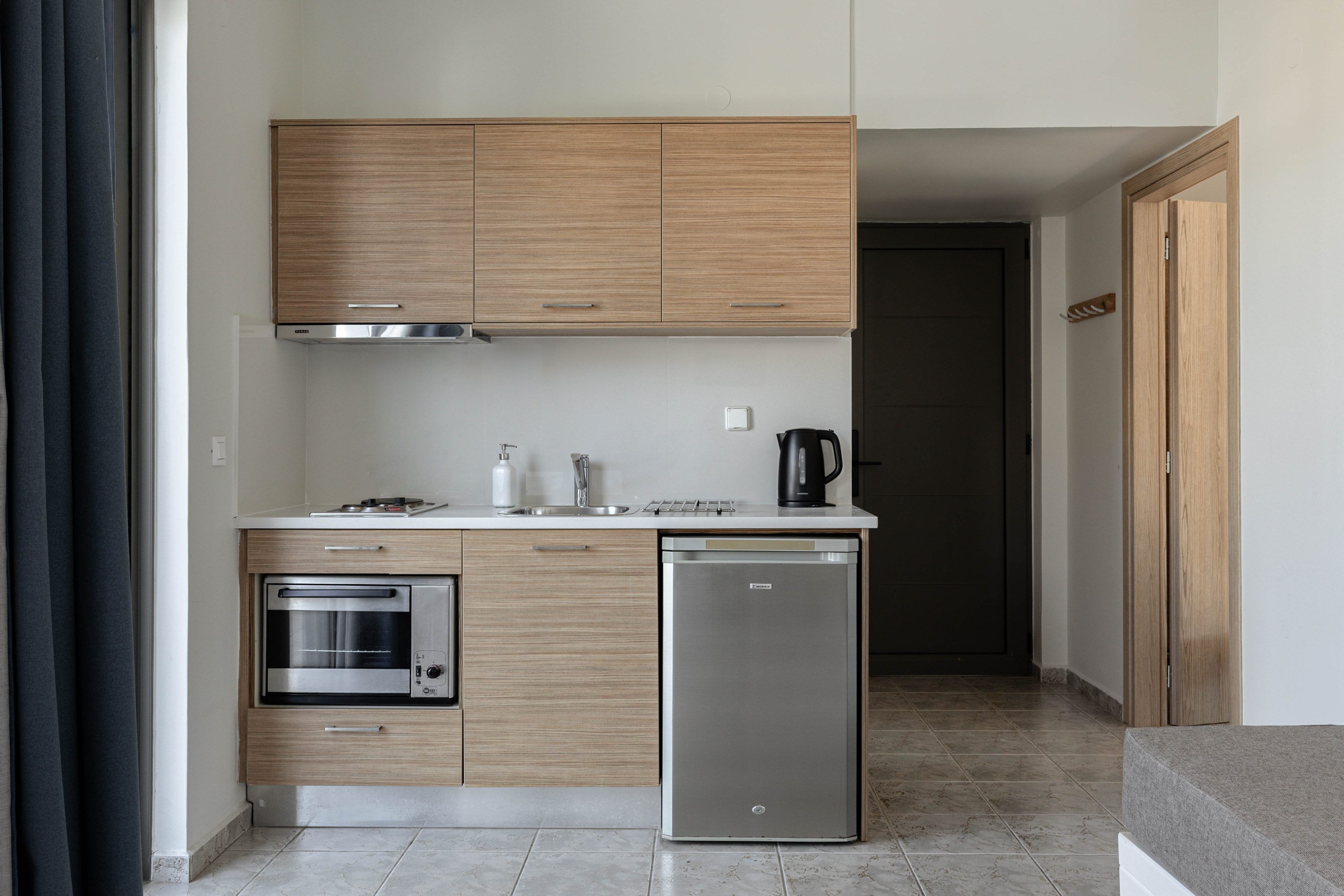 A modern kitchen with wooden cabinets, a built-in oven, a dishwasher, and a coffee maker.