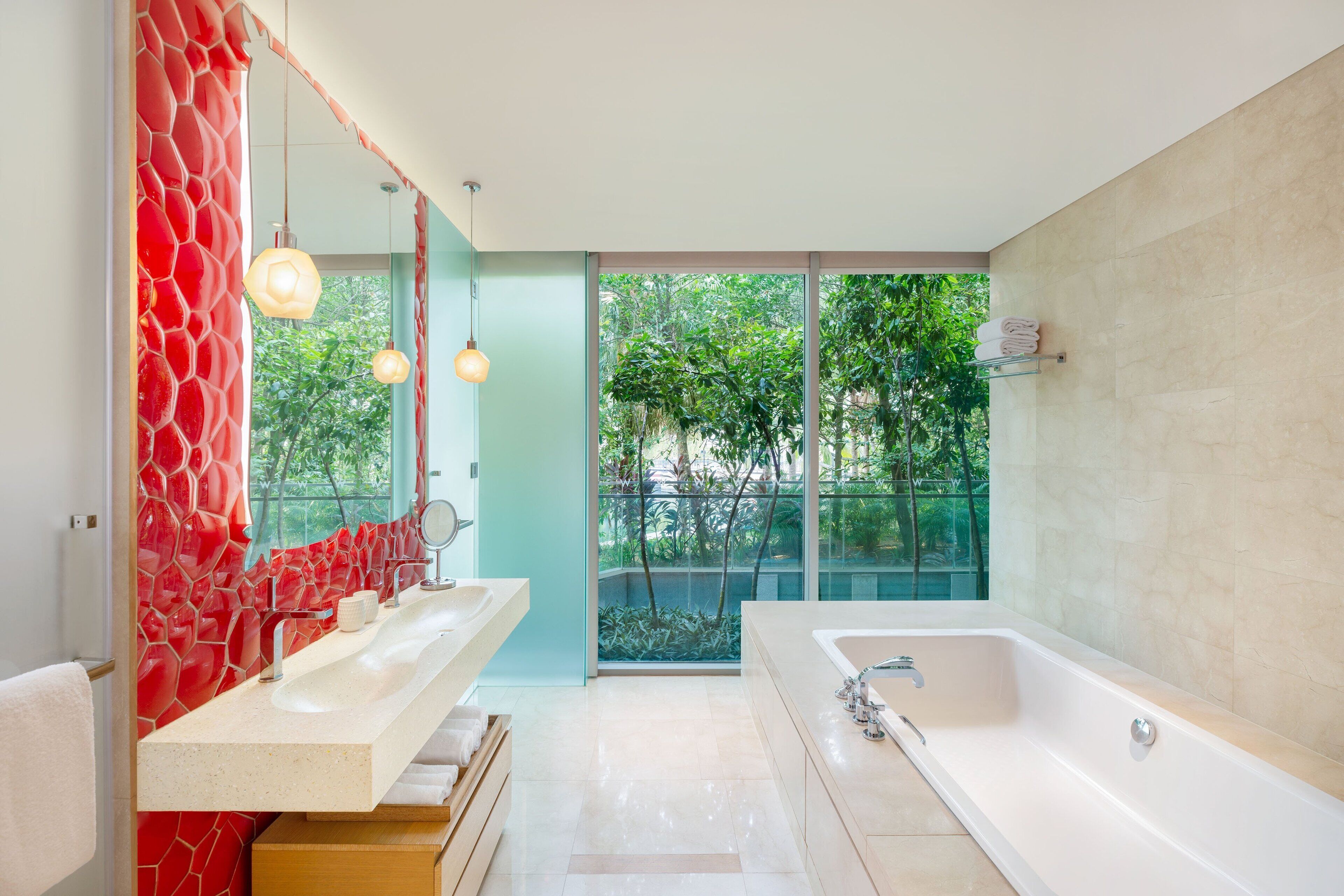 Une salle de bain moderne dotée d’une grande baignoire, de deux vasques et d’une douche à parois en verre.
