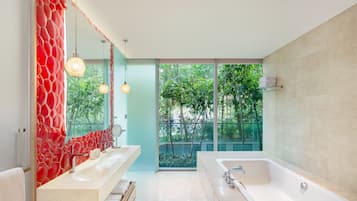 Une salle de bain moderne dotée d’une grande baignoire, de deux vasques et d’une douche à parois en verre.