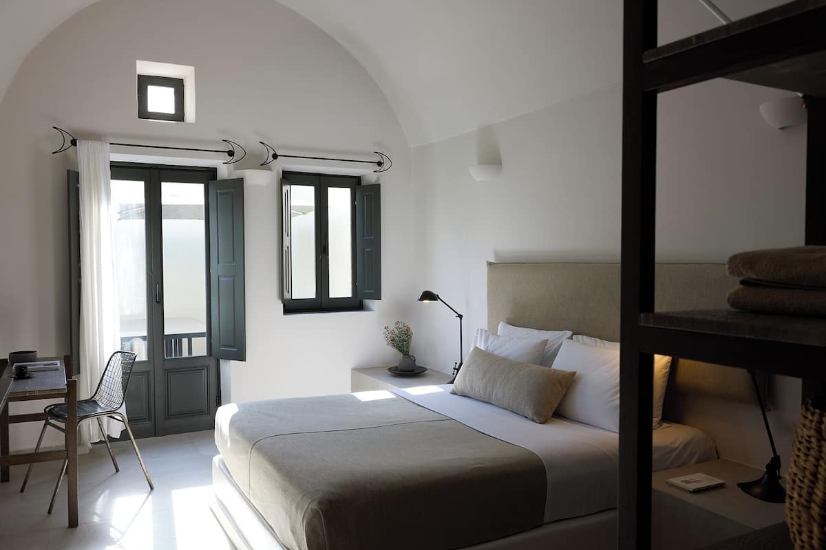 Une chambre à coucher avec un lit, une table de chevet, une lampe et une chaise.