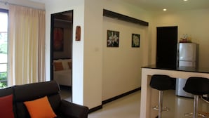 A modern hotel room with a living area, a kitchenette, and a dining space. - Leelawadee Garden Resort (Krabi)