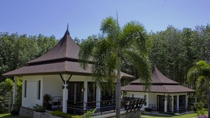 A two-story building with a covered porch and a small garden area. - Leelawadee Garden Resort (Krabi)