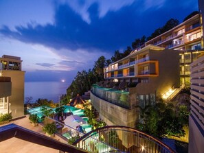 A hotel with multiple floors, outdoor swimming pool, and lush greenery. - Kalima Resort & Spa, Phuket (Patong)