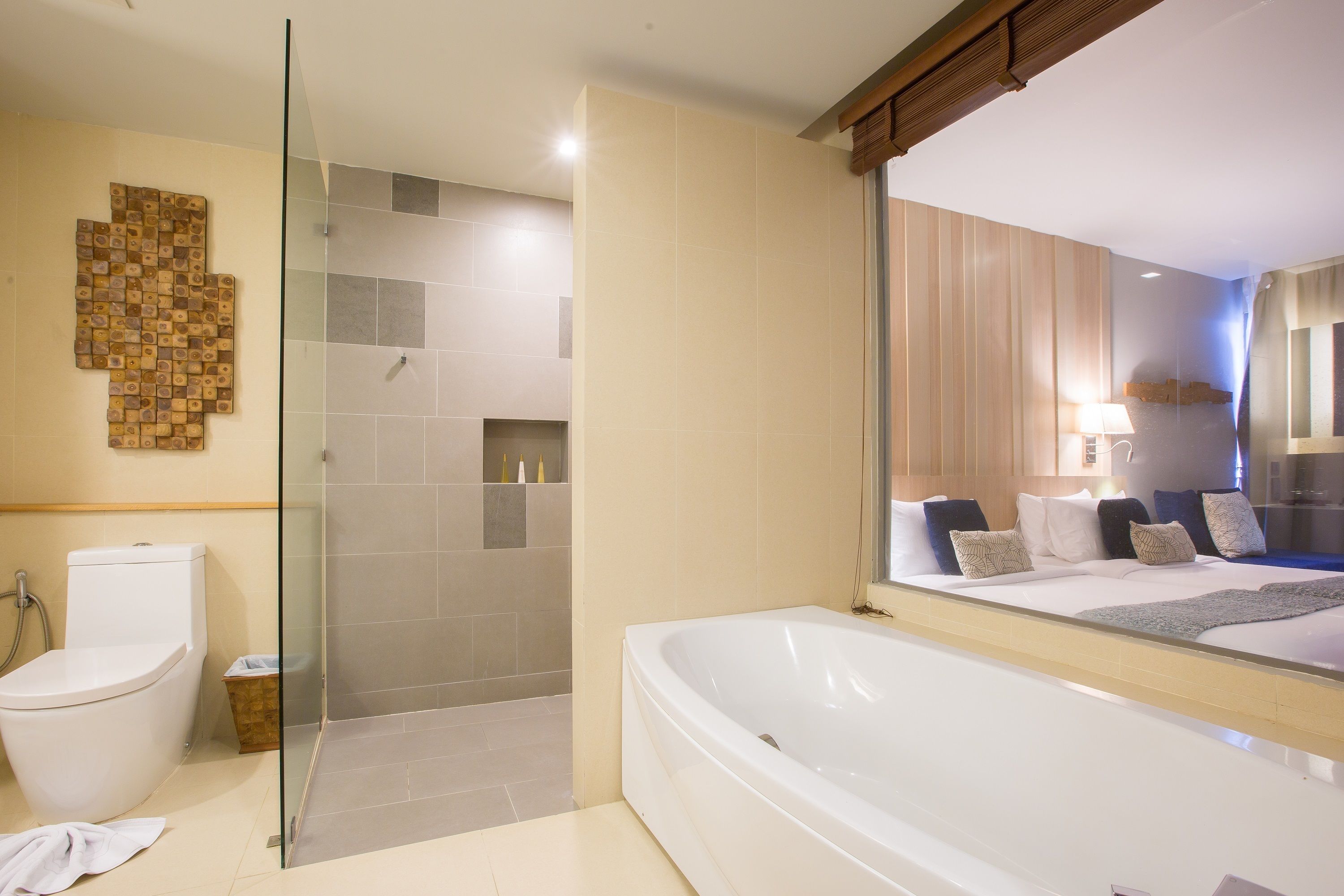 Un baño moderno con cabina de ducha de vidrio, una bañera grande y un inodoro.