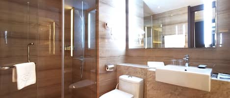 A modern bathroom with a glass-enclosed shower, a toilet, and a vanity with a mirror.
