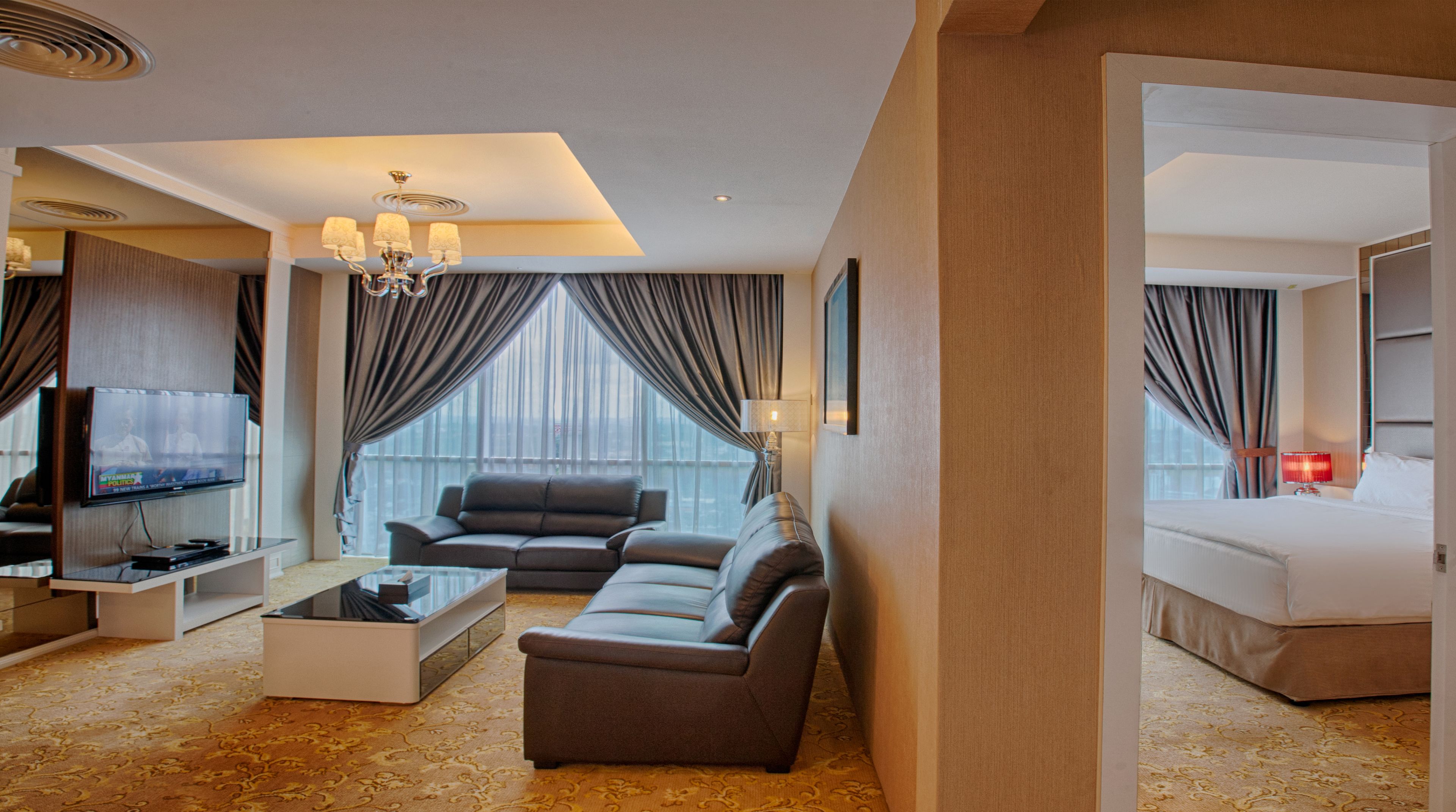 Une chambre d’hôtel moderne équipée d’un canapé, d’une table basse, d’un téléviseur et d’un lit.