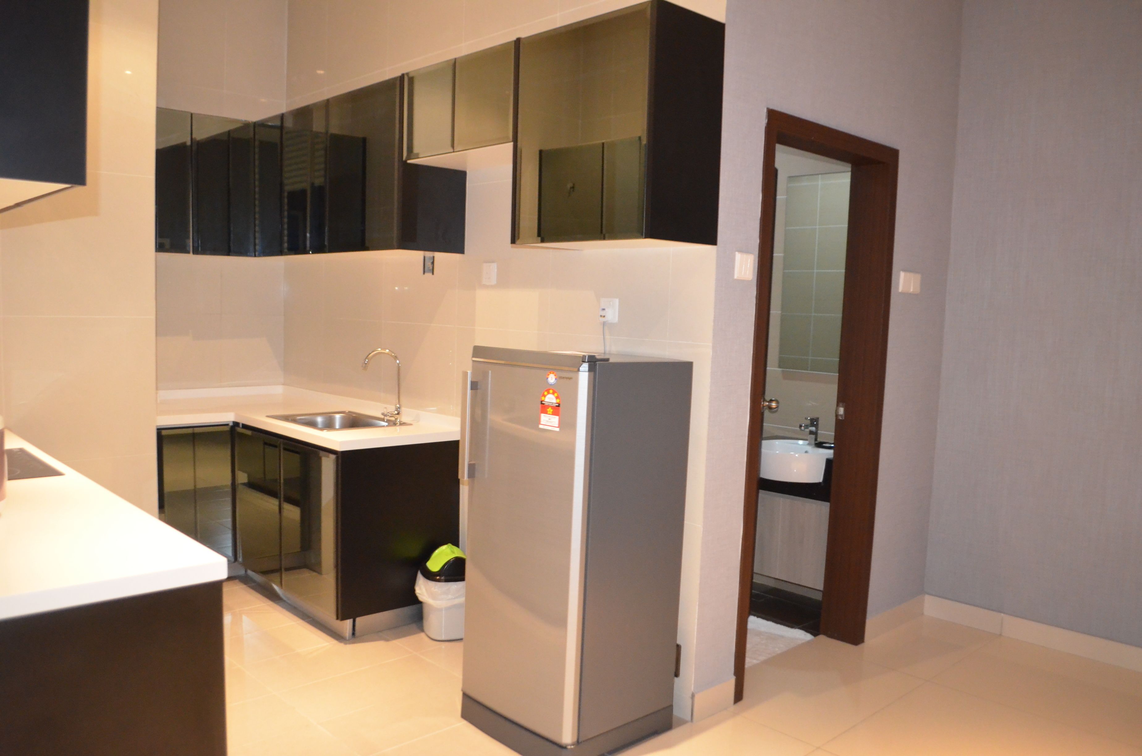 A modern kitchen with a refrigerator, sink, and cabinets.