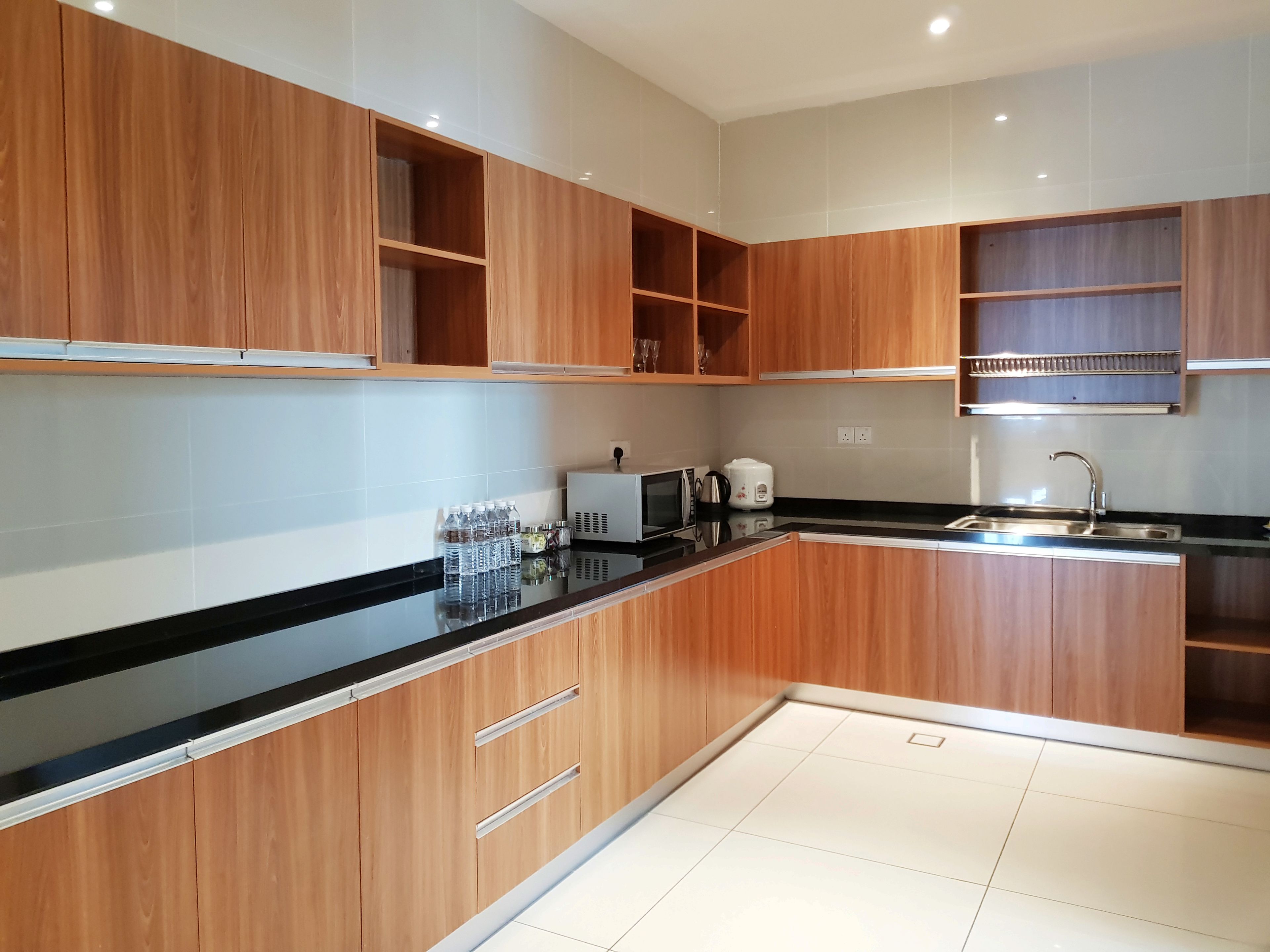 Een moderne keuken met houten kastjes, een zwart aanrecht en een roestvrijstalen spoelbak.