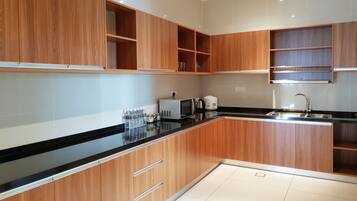 Een moderne keuken met houten kastjes, een zwart aanrecht en een roestvrijstalen spoelbak.