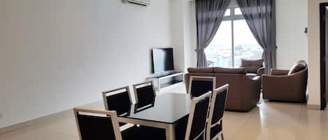 A modern living room with a dining area, a flat-screen TV, and a ceiling fan.