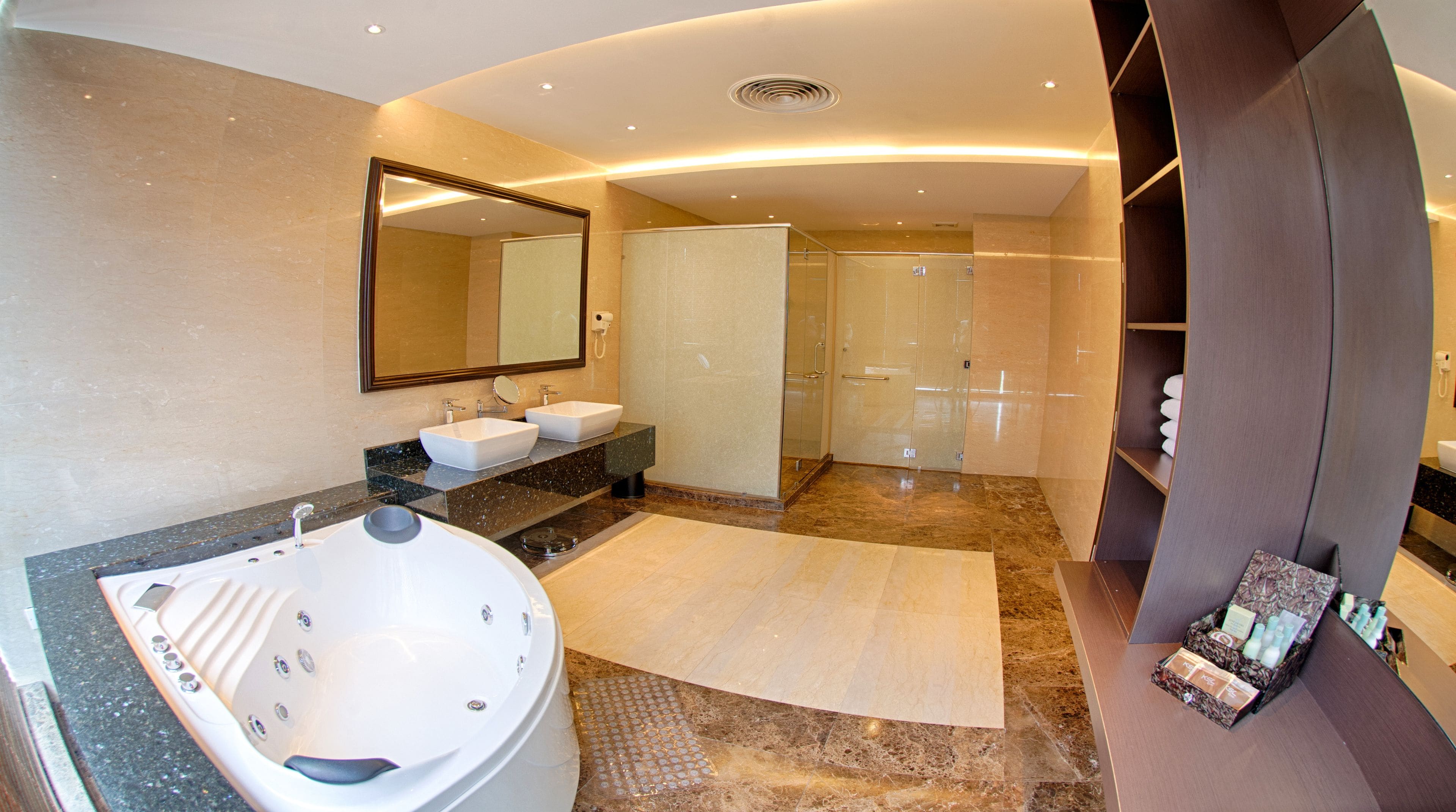 A modern bathroom with a large bathtub, two sinks, a walk-in shower, and a vanity with a mirror.
