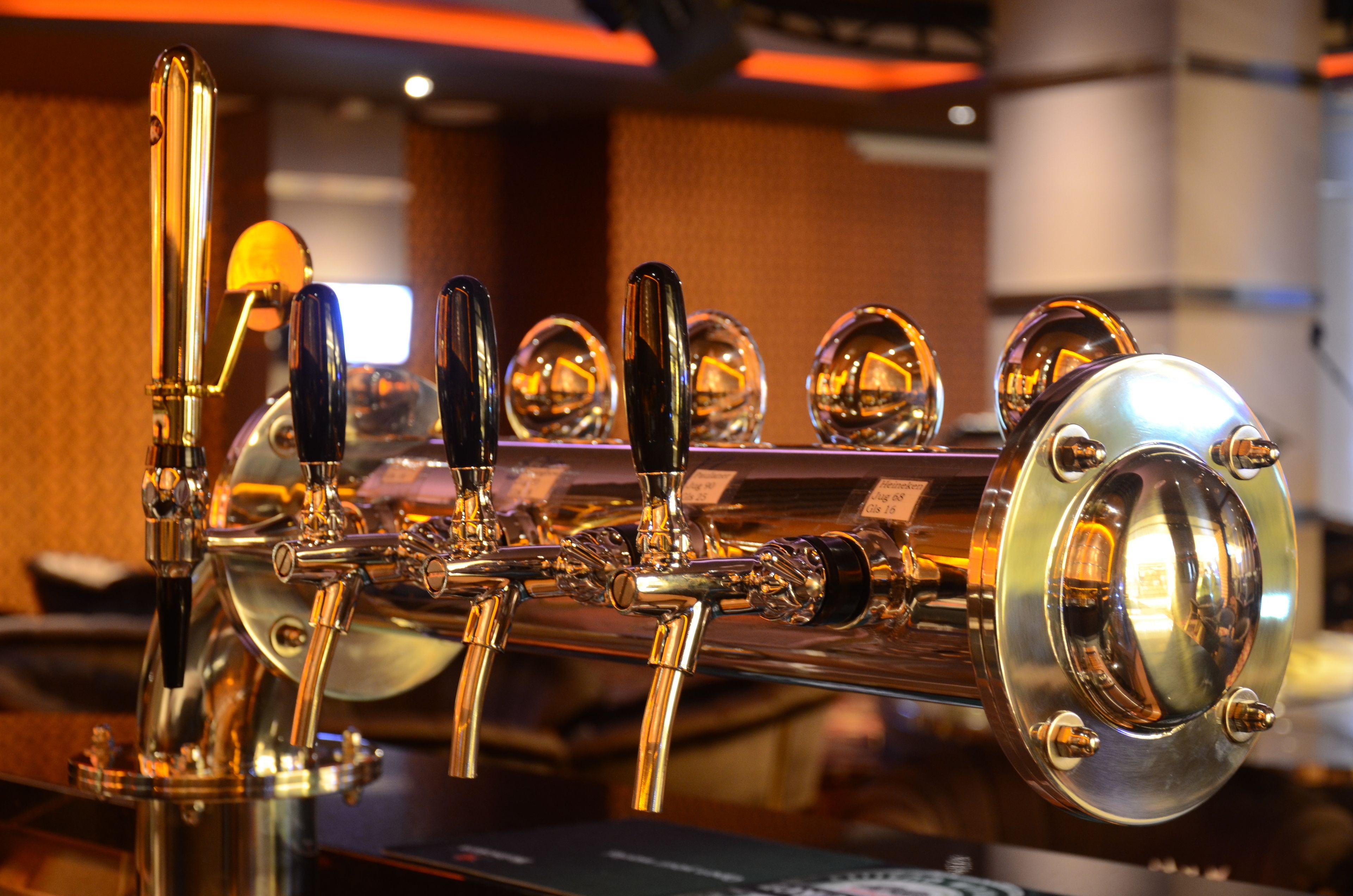 A close-up of a bar with multiple taps and a polished counter.