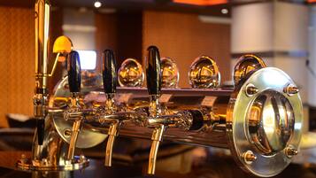 A close-up of a bar with multiple taps and a polished counter.