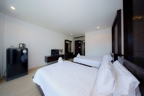 A hotel room with two beds, a TV, a minibar, and a mirror. - Aonang Regent (Krabi)