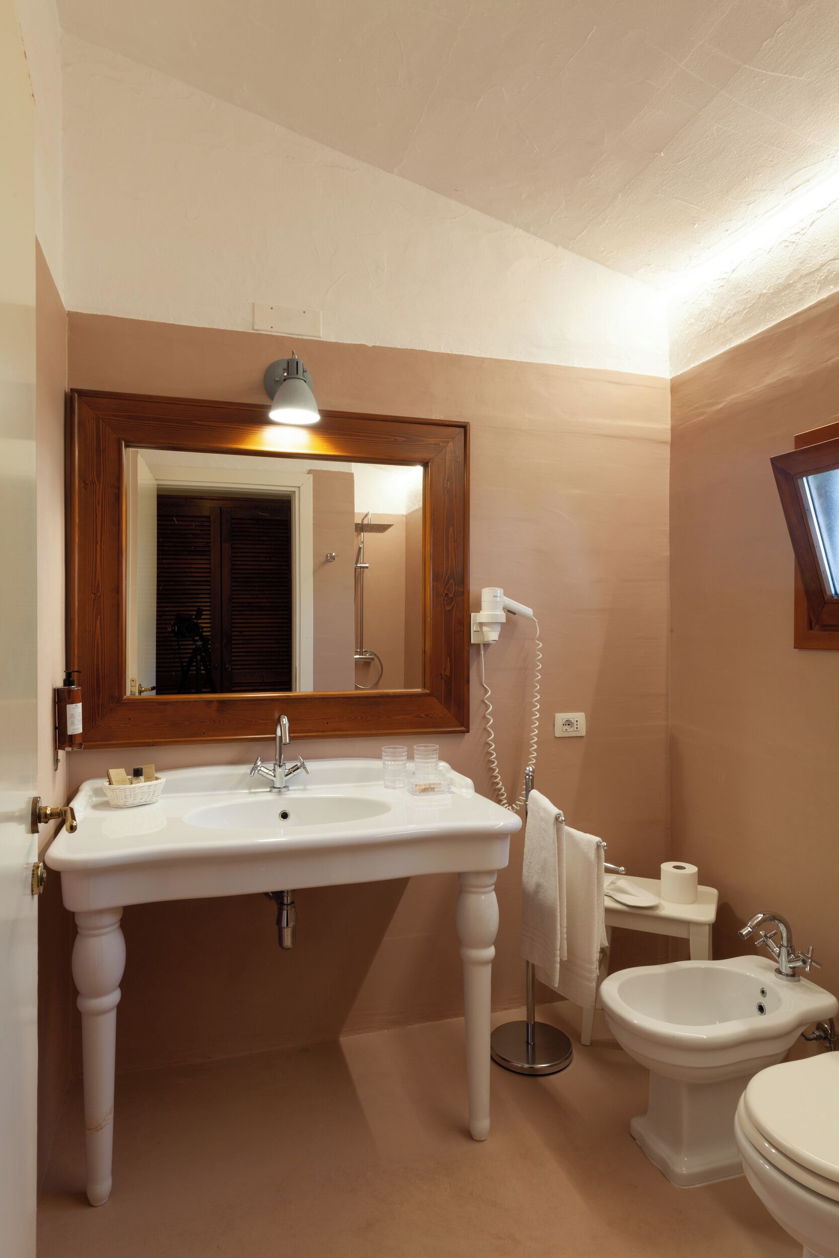 Un baño con lavamanos blanco, un bidé y un inodoro.