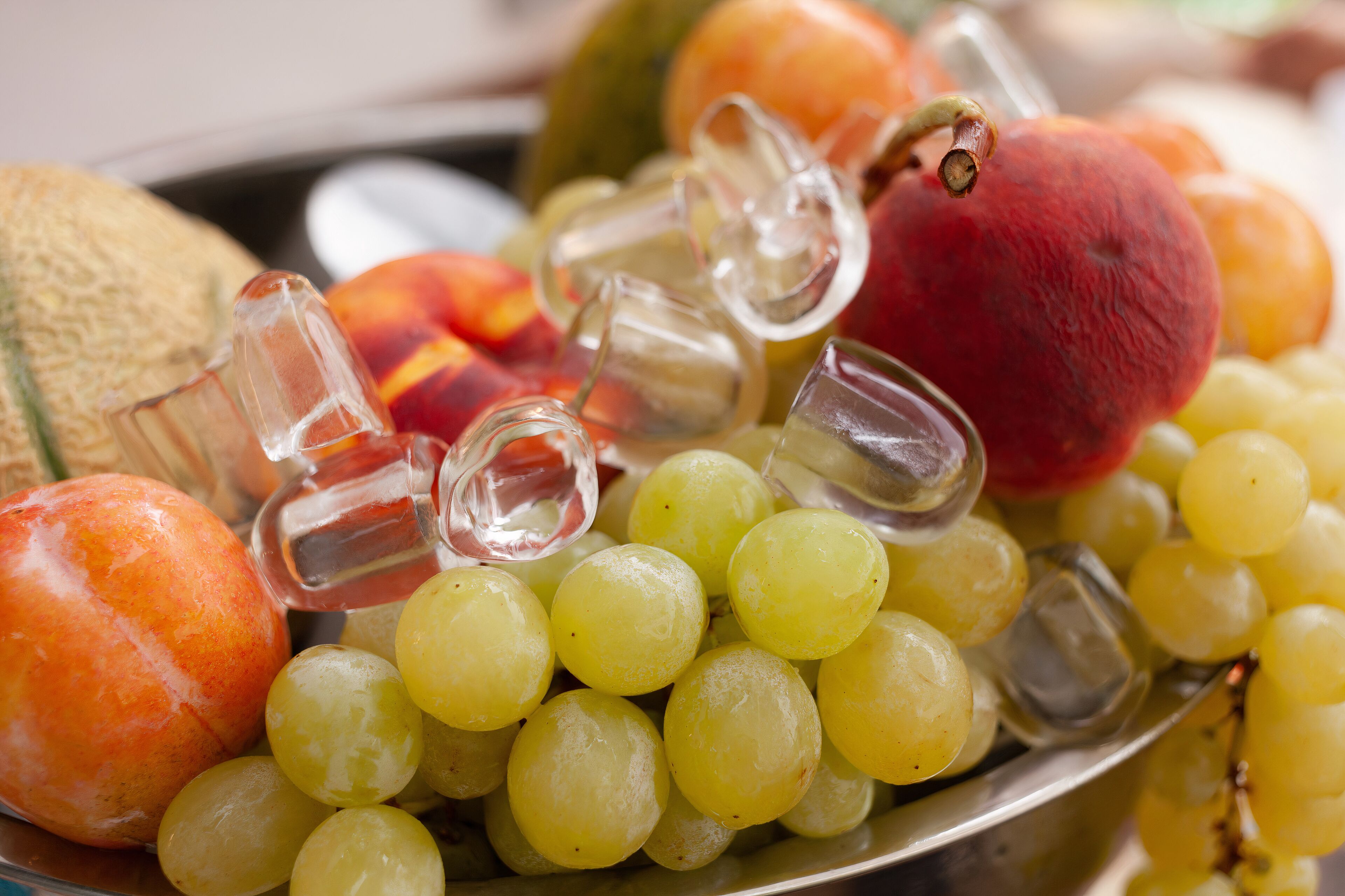 A fruit platter with grapes, peaches, and a melon.