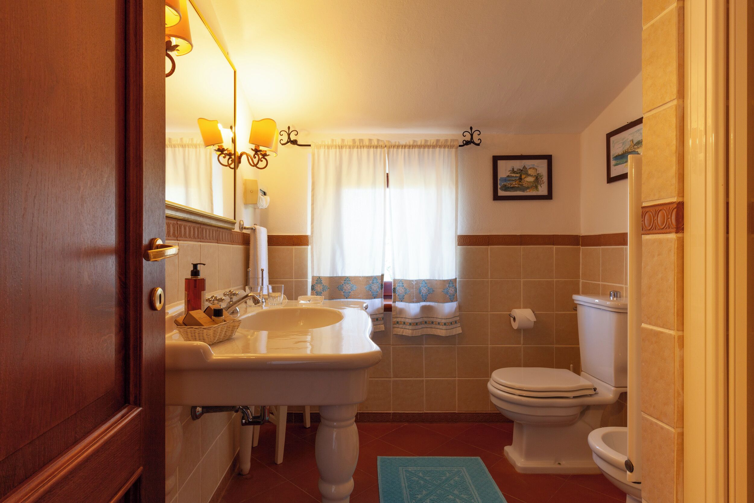 A bathroom with a sink, mirror, and toilet.