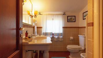 A bathroom with a sink, mirror, and toilet.