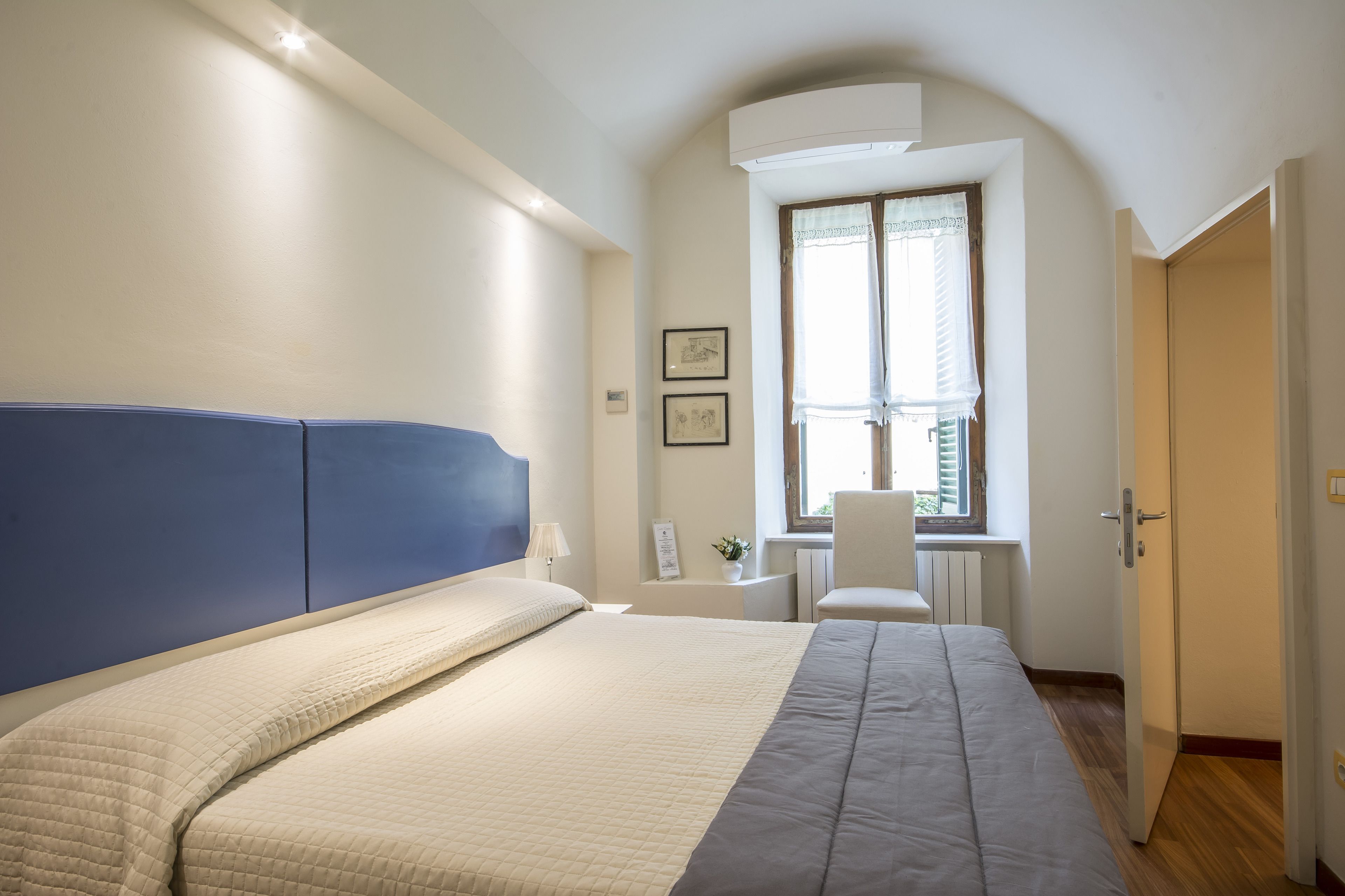 Un dormitorio con cama, escritorio y silla.
