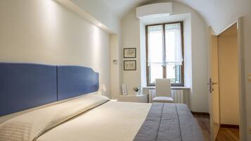 Un dormitorio con cama, escritorio y silla.