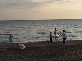 Escena de playa con gente practicando actividades acuáticas.