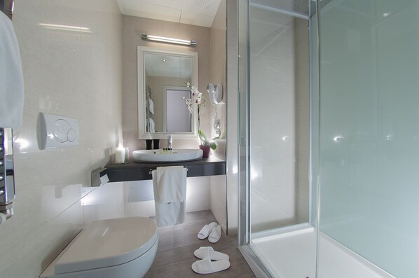 Un baño moderno con inodoro, lavabo y ducha.