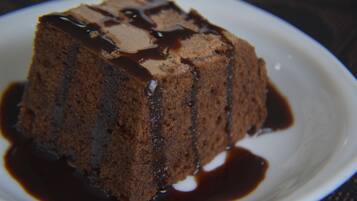 Sobremesa de chocolate num prato com calda brilhante.