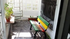 Un sol carrelé, des bancs et une clôture blanche.