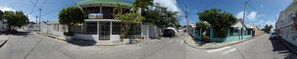 A street view with a building that has a gated entrance and a signboard.
