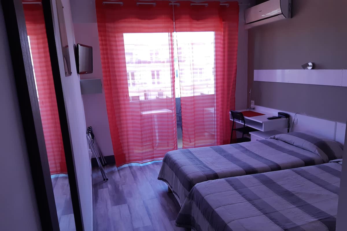 Une chambre avec deux lits, un bureau et une chaise.