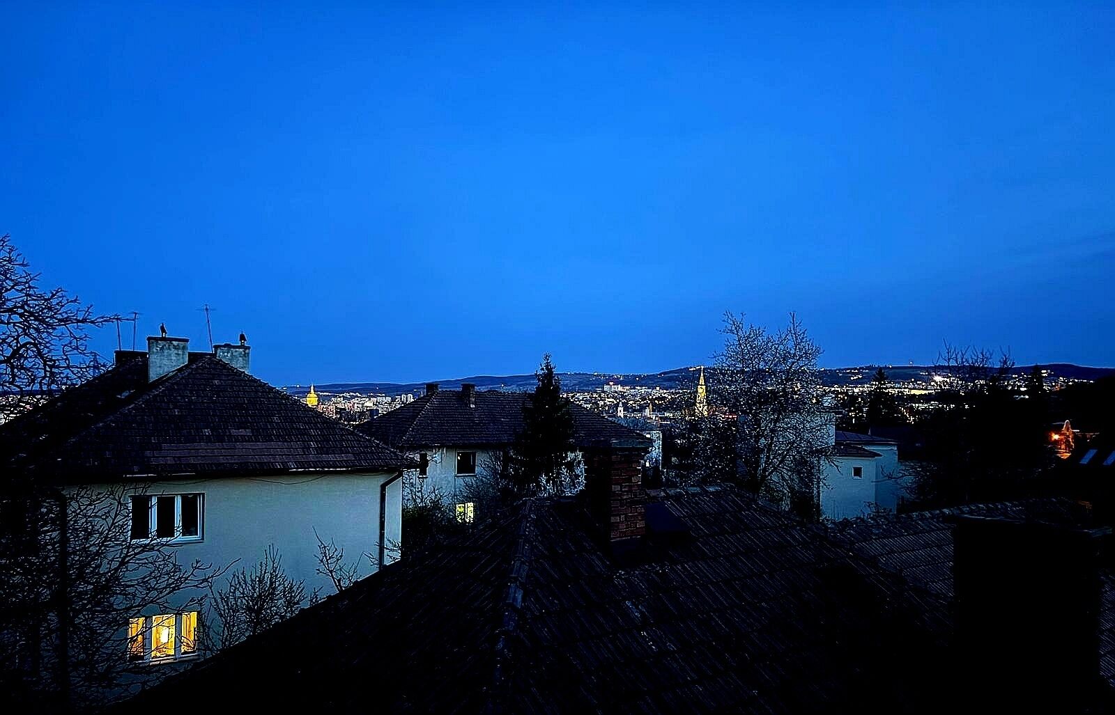 A nighttime view of a town with buildings and a prominent church spire.