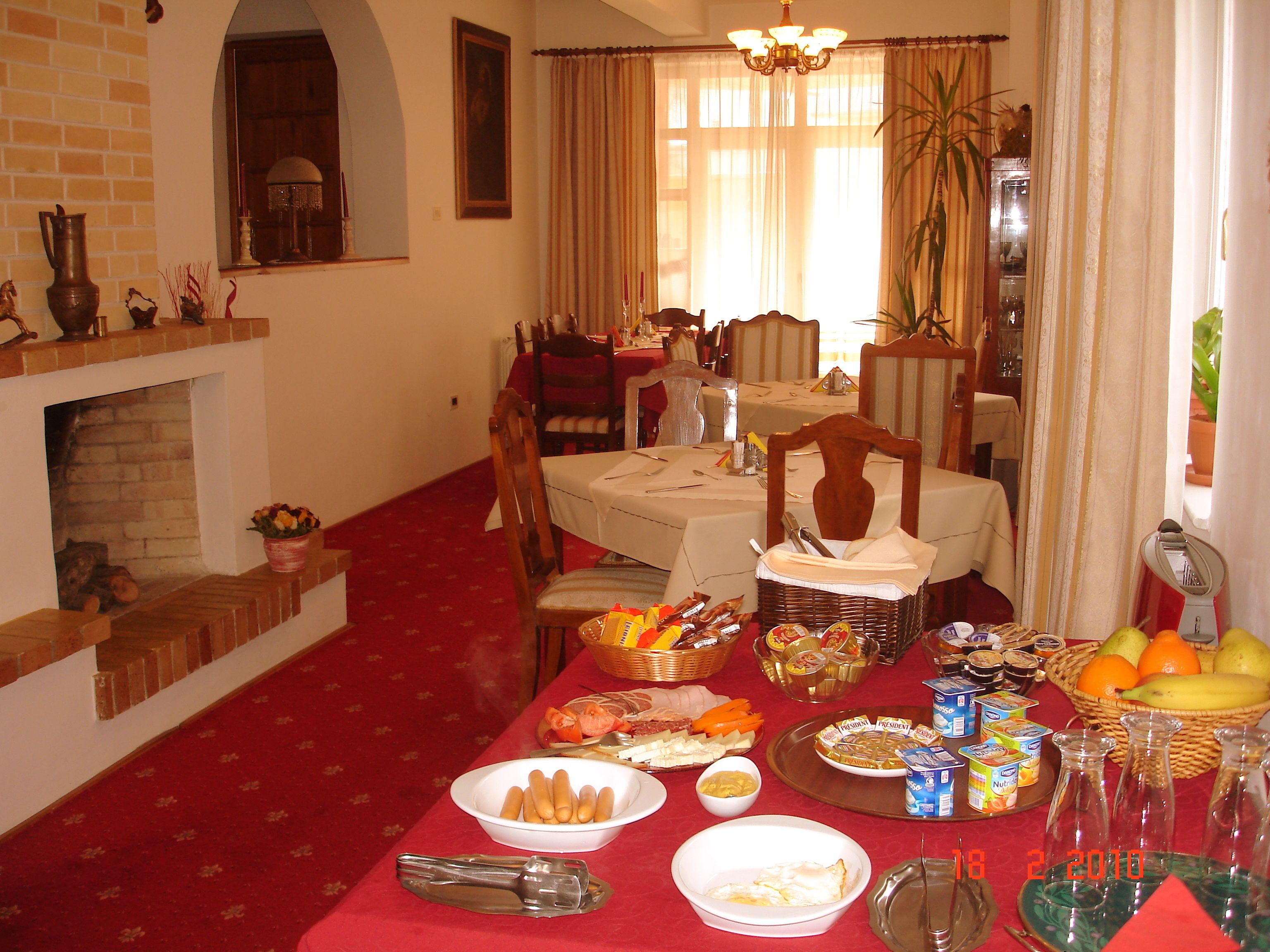 A dining area with a fireplace, a chandelier, and a table set for a meal.