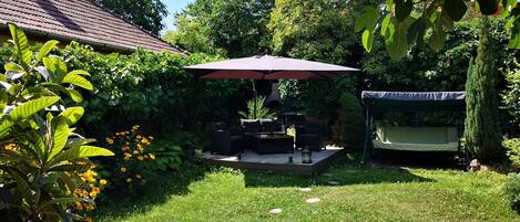 A patio with outdoor furniture, a barbecue grill, and a covered seating area.