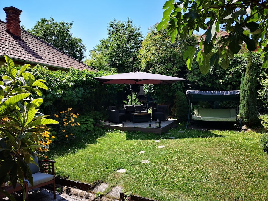 A patio with outdoor furniture, a barbecue grill, and a covered seating area.