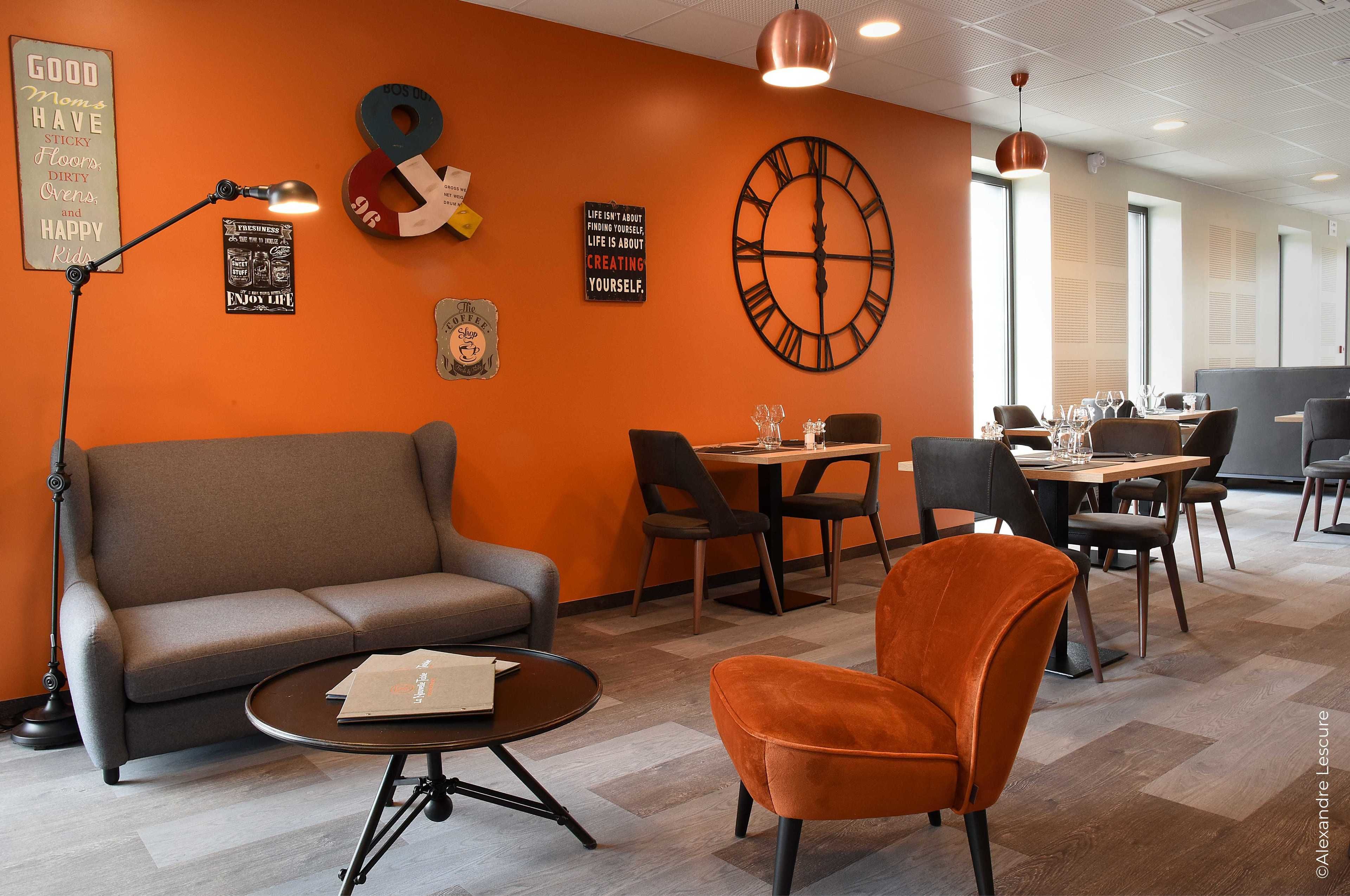 Un espace de détente moderne comprenant un canapé, des fauteuils, une table basse et une table à manger avec des chaises.