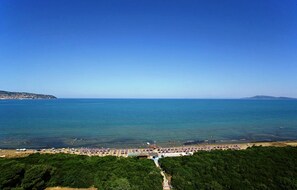 A coastal beach with a clear view of the sea and a distant island.