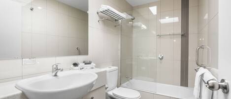 A modern bathroom with a sink, toilet, and shower.
