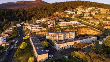 A residential area with modern houses, a main road, and a mountain in the background.