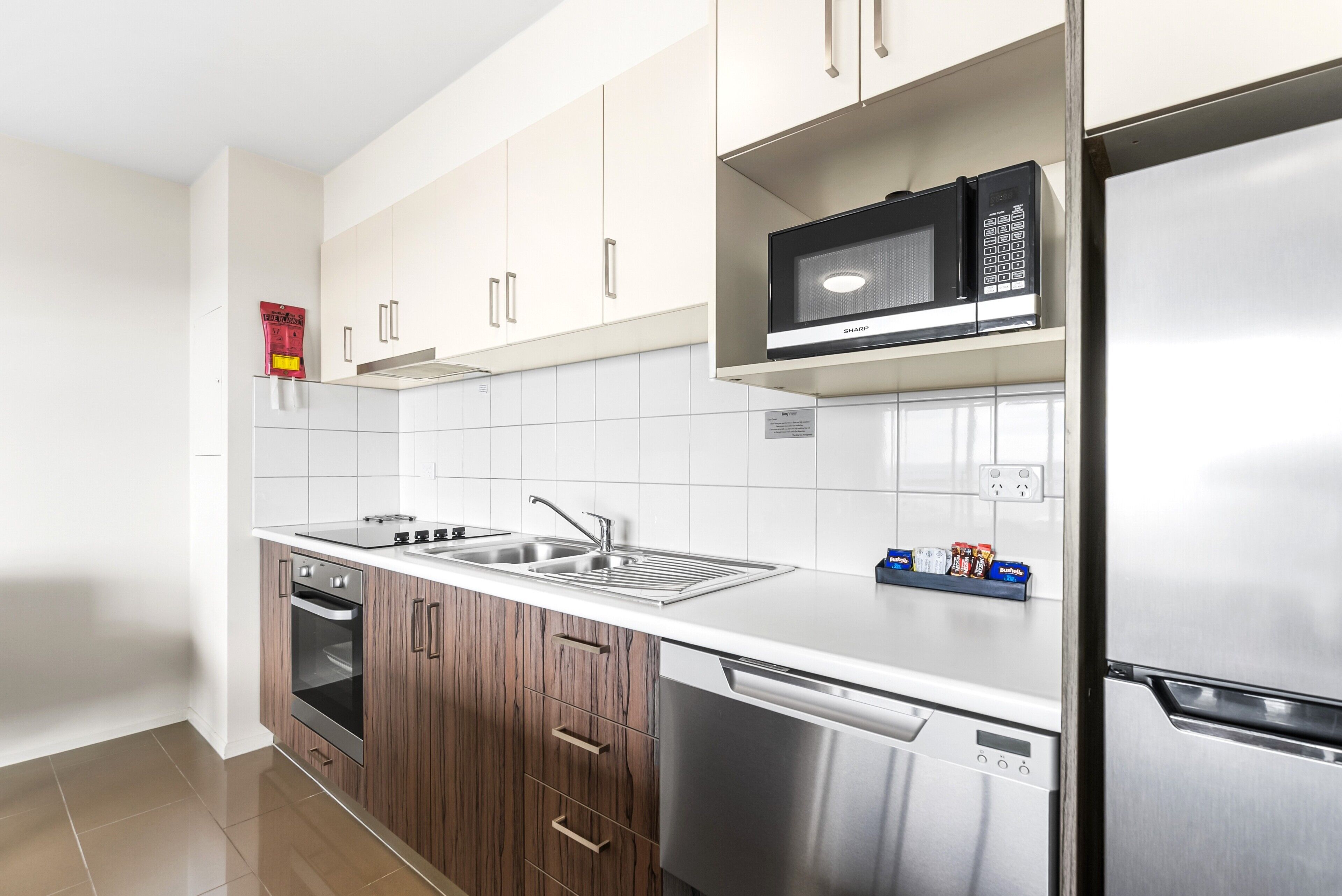Een moderne keuken met roestvrijstalen apparatuur, een vaatwasser en een magnetron.