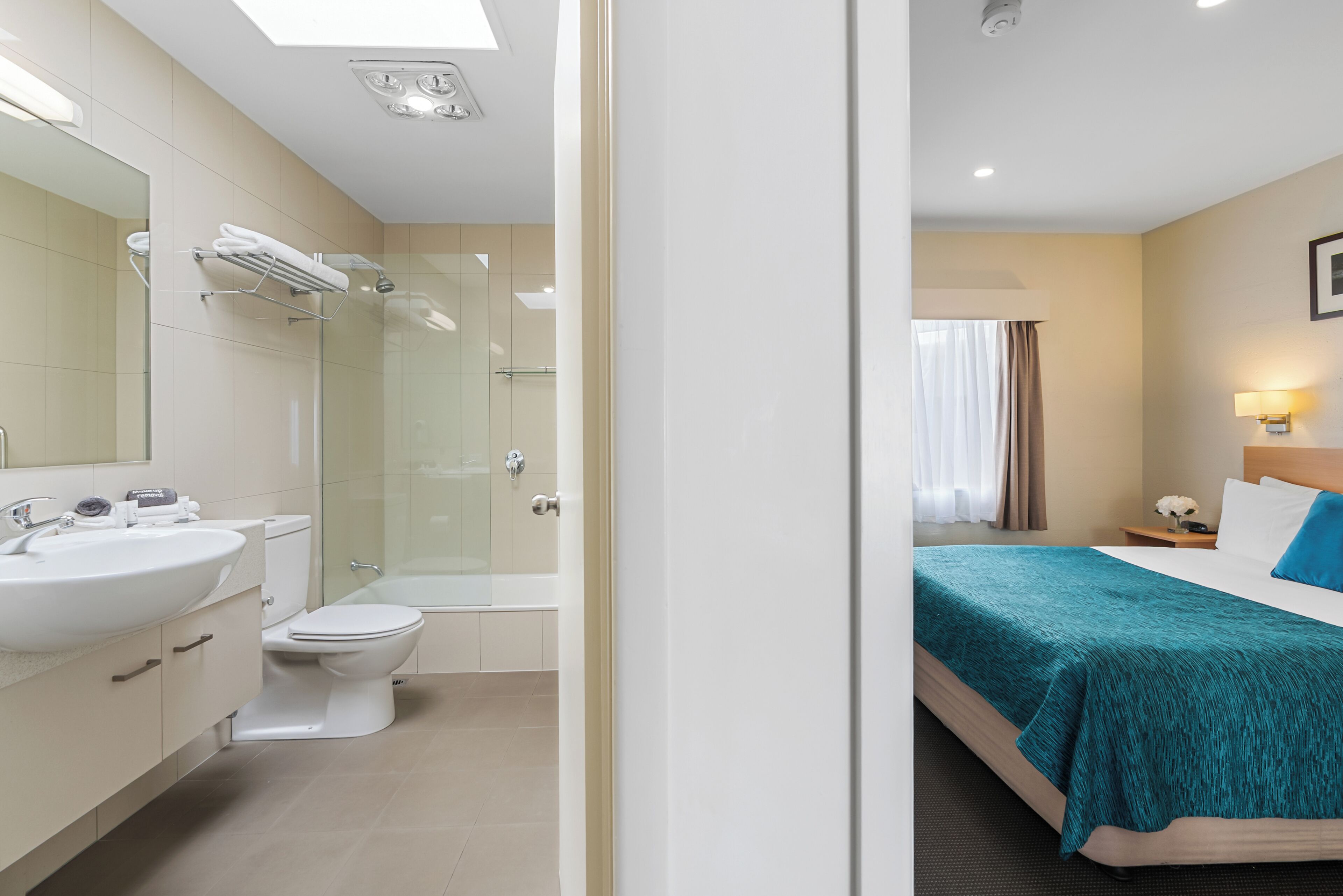 A hotel bathroom with a sink, toilet, and shower.